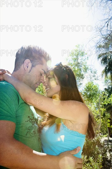 Hispanic couple hugging outdoors