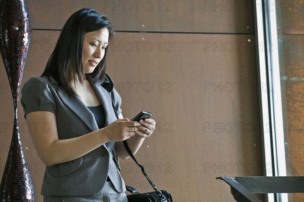 Asian businesswoman looking at cell phone