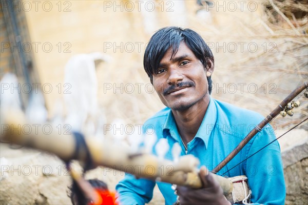Indian man holding traditional instrument