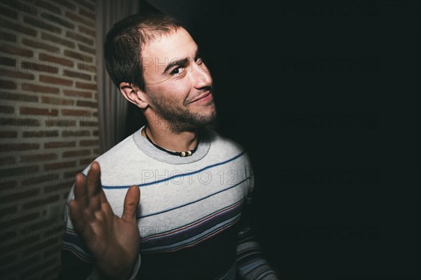 Close up of smiling man waving at night