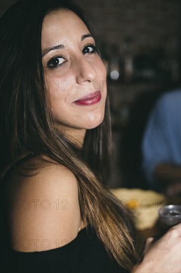 Close up of Hispanic woman drinking in nightclub