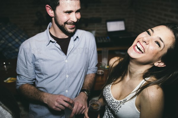 Couple laughing and drinking in nightclub