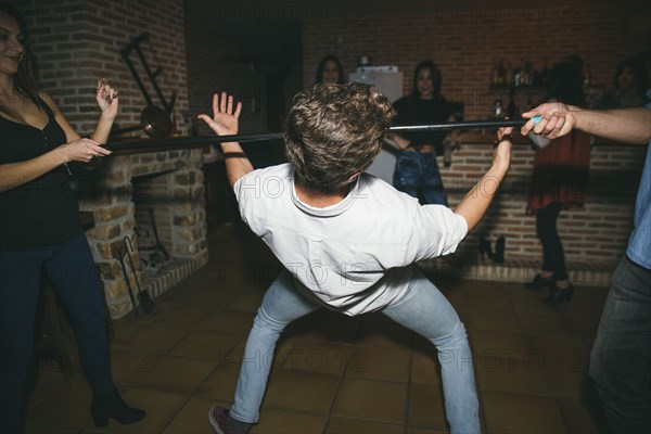 Friends dancing limbo in nightclub