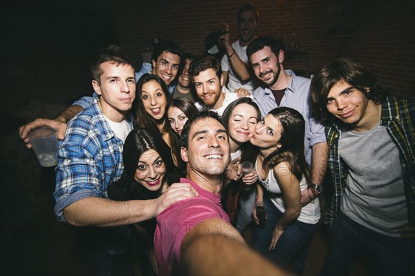 Smiling friends taking selfie in nightclub