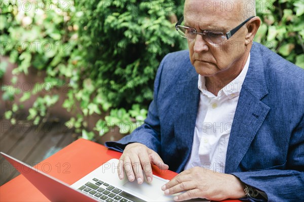 Hispanic businessman using laptop outdoors