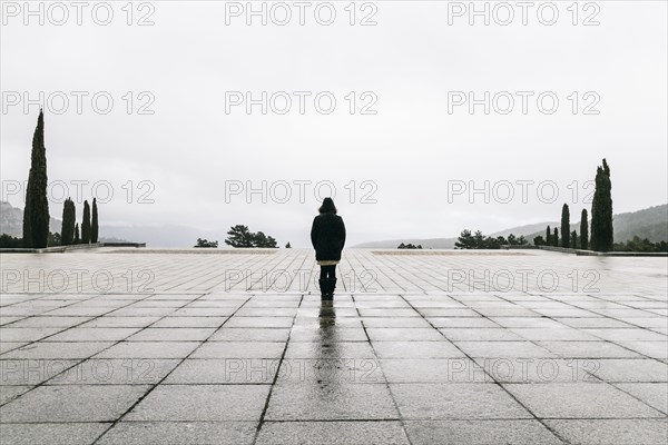 Caucasian woman walking in concrete courtyard