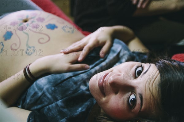 Pregnant Caucasian woman with drawings on belly