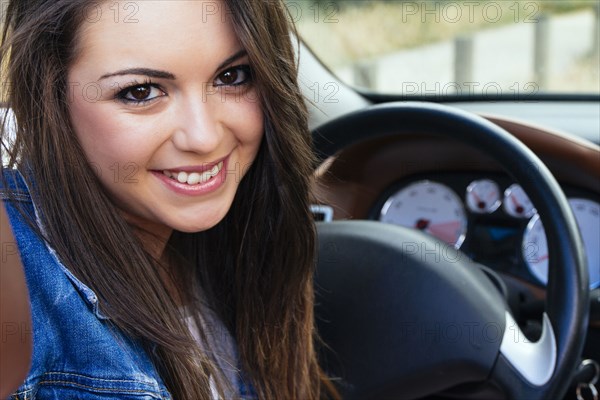 Hispanic woman smiling in car