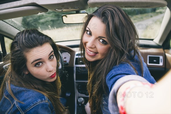 Women taking selfie in convertible