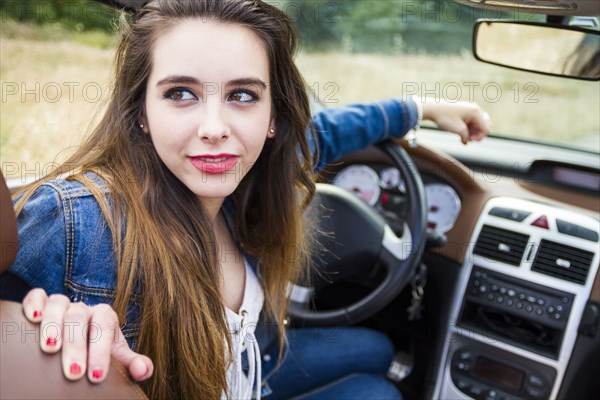 Caucasian woman sitting in convertible