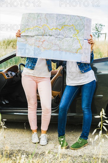 Women reading map on road trip