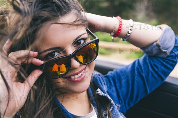 Hispanic woman peering over sunglasses