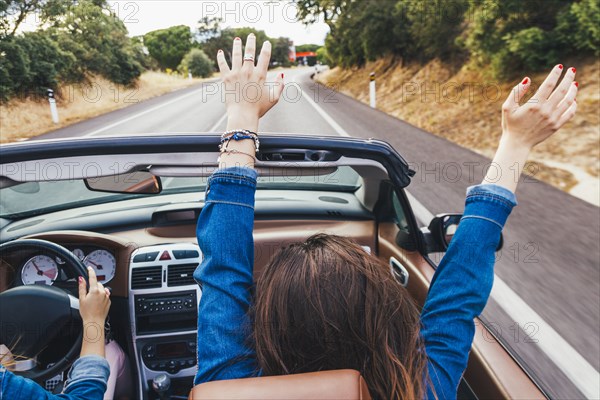 Woman cheering in convertible