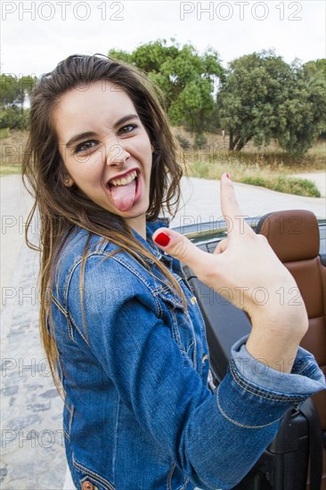 Caucasian woman making a face near car