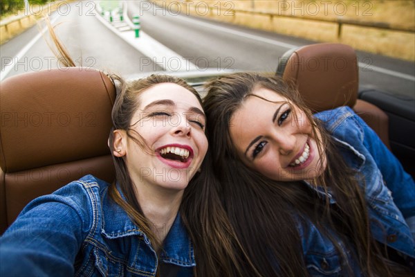 Women laughing in convertible
