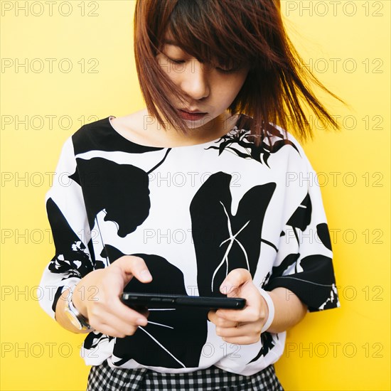 Chinese woman using cell phone in wind