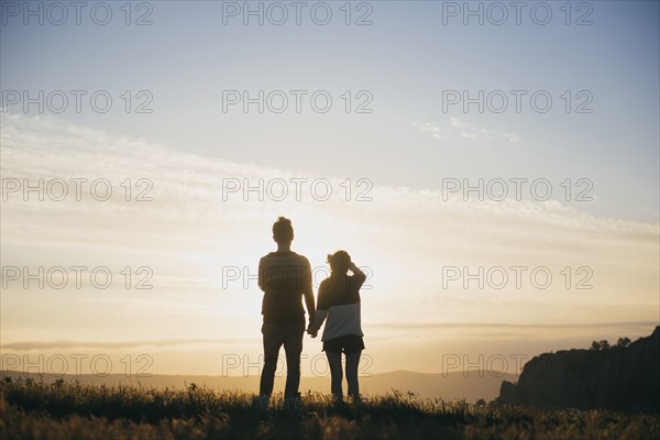 Caucasian couple admiring scenic view at sunset