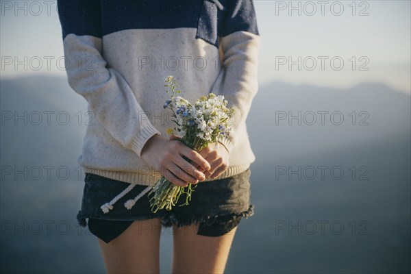 Caucasian woman holding bouquet of wildflowers