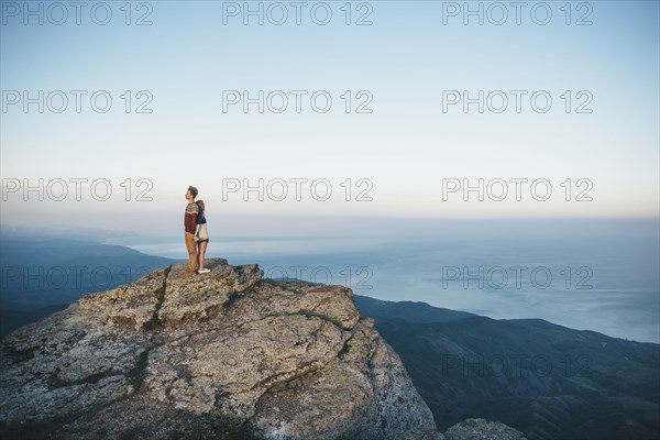 Caucasian couple standing back to back on mountain