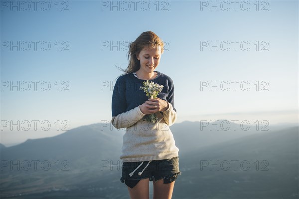 Caucasian woman holding bouquet of wildflowers