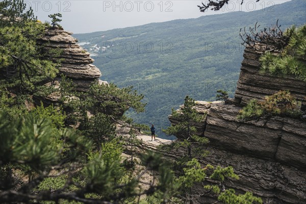 Distant Caucasian man standing in mountain landscape