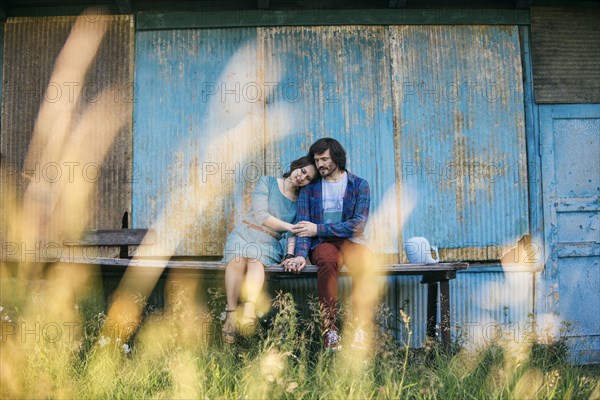 Caucasian couple holding hands sitting on table outdoors