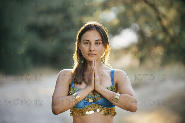 Caucasian belly dancer with hands clasped