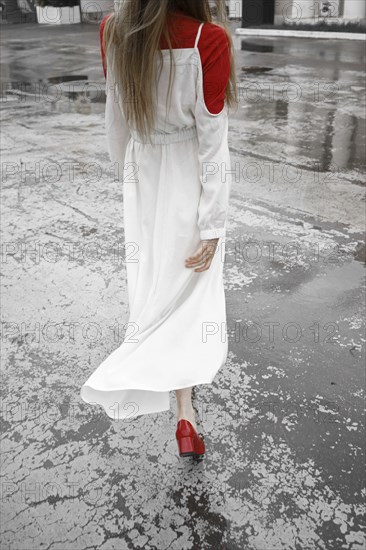 Rear view of Caucasian woman walking in rain