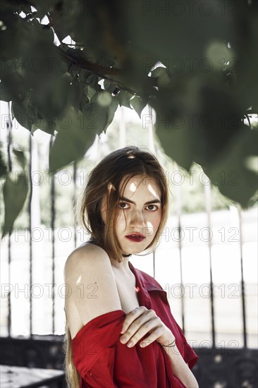 Serious Caucasian woman under tree branch