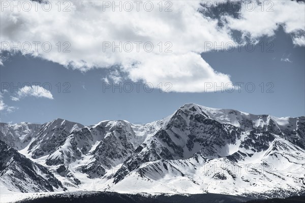 Clouds over snow covered mountains