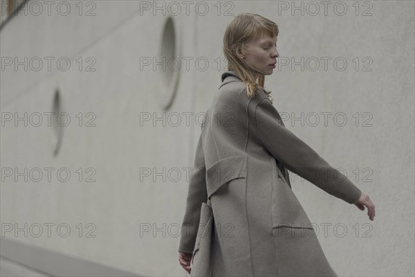 Wind blowing hair of Caucasian woman wearing coat