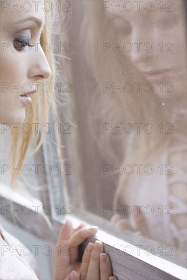 Reflection of Caucasian woman leaning on window