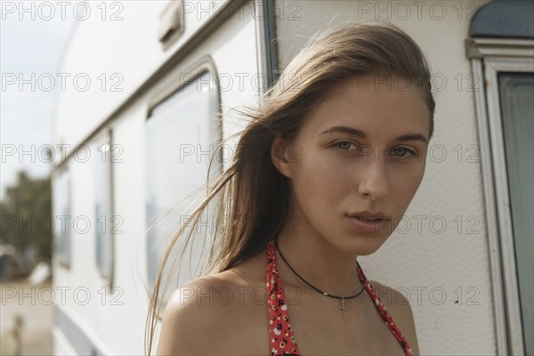 Serious Caucasian woman standing near trailer