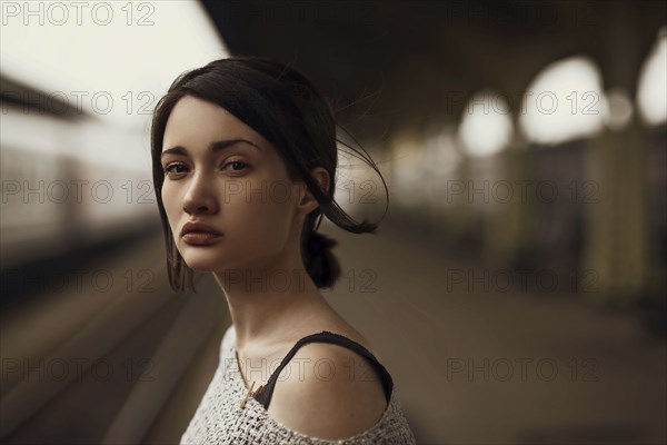 Portrait of serious Caucasian woman at train station