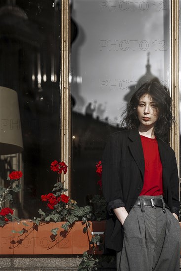 Caucasian woman leaning on flower box near window