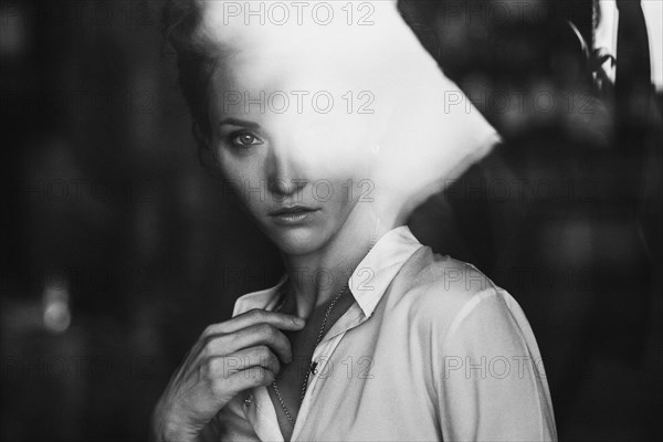 Portrait of Caucasian woman behind window