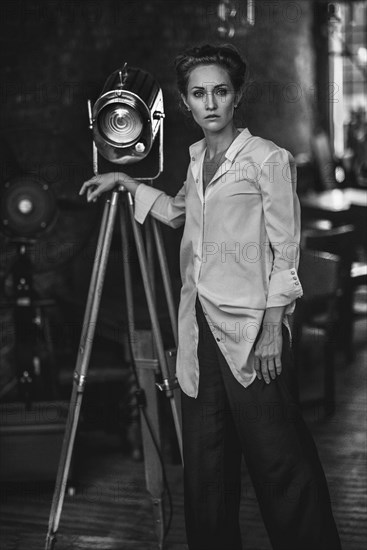 Serious Caucasian woman standing near light