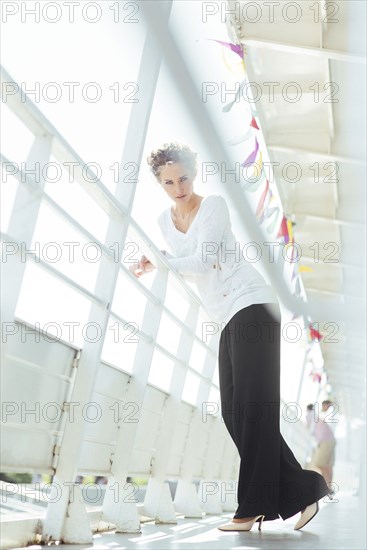 Glamorous Caucasian woman leaning on railing