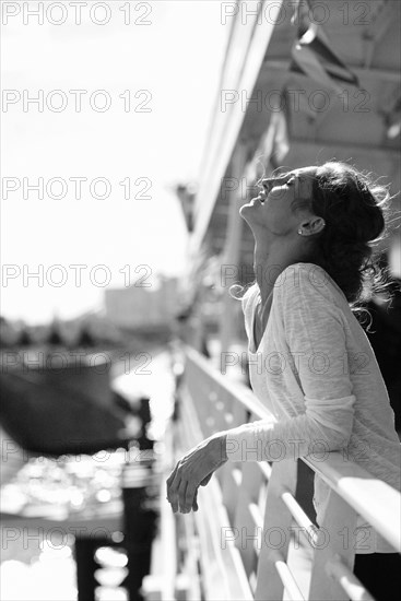 Caucasian woman relaxing and leaning on railing