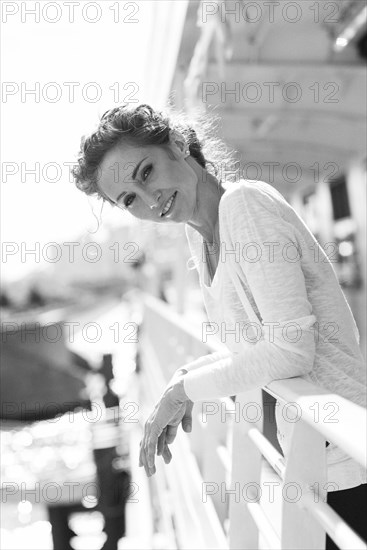 Portrait of smiling Caucasian woman leaning on railing