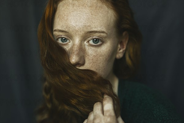 Caucasian woman covering mouth with hair