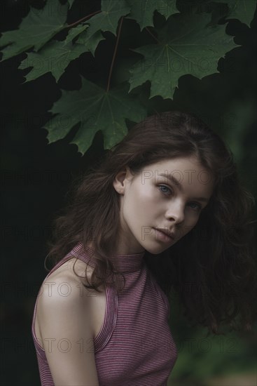 Caucasian woman standing under leaves