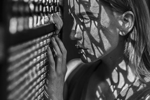 Caucasian woman with freckles leaning on window