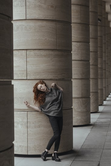 Carefree Caucasian woman leaning on pillar