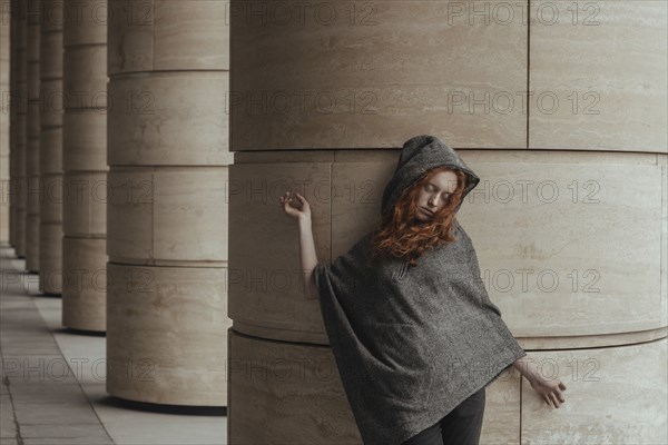 Carefree Caucasian woman leaning on pillar