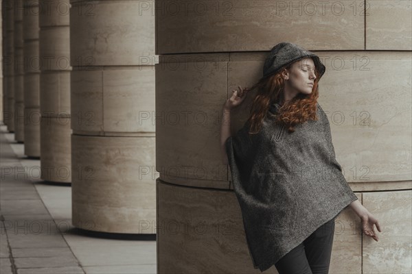 Carefree Caucasian woman leaning on pillar