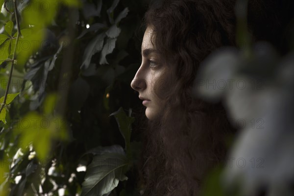 Profile of serious Caucasian woman in leaves