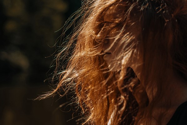 Wind blowing red hair of Caucasian woman