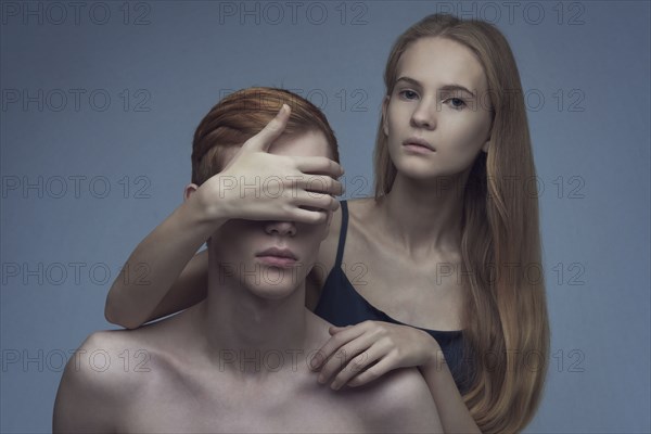 Caucasian woman covering eyes of man