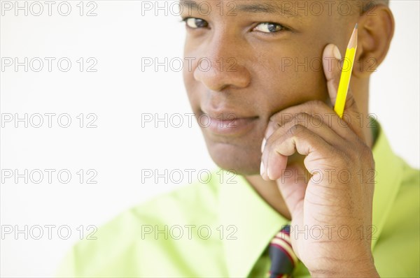 Portrait of businessman holding pencil